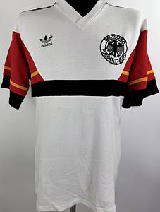 DFB - Trikot 1986 WM  | Für das WM-Finale 1986 in Mexiko Deutschland gegen Argentinien wurde dieses besondere Trikot ursprünglich für Matthias Herget vorbereitet. Das Shirt basiert auf dem seltenen weißen adidas-Design im Stil des damaligen Trainingsoberteils.ach damaliger Entscheidung der FIFA kam dieses Trikot im Finale jedoch nicht zum Einsatz. Da Argentinien als Heimteam geführt wurde, galt die Farbkombination des weißen deutschen Trikots im Zusammenspiel mit den hellblauen argentinischen Streifen als zu ähnlich. Um mögliche Verwechslungen zu vermeiden, lief das DFB -Team deshalb erneut im grünen Auswärtstrikot aus dem Vorrundenspiel gegen Uruguay auf. Trikot kommt aus der Sammlung vom deutschen Nationalspieler Matthias Herget Status AAA,. - Bild 2
