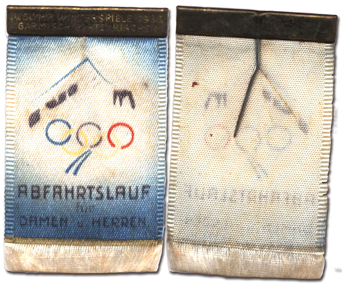 Eintrittsabzeichen OS1936  | Eintrittsabzeichen für den Besuch „Abfahrtslauf für Damen und Herren“ Seide mehrfarbig bedruckt mit geprägten Messingschildchen „IV.Olymp. Winterspiele 1936. Garmisch-Partenkirchen“. 6x3,4cm.