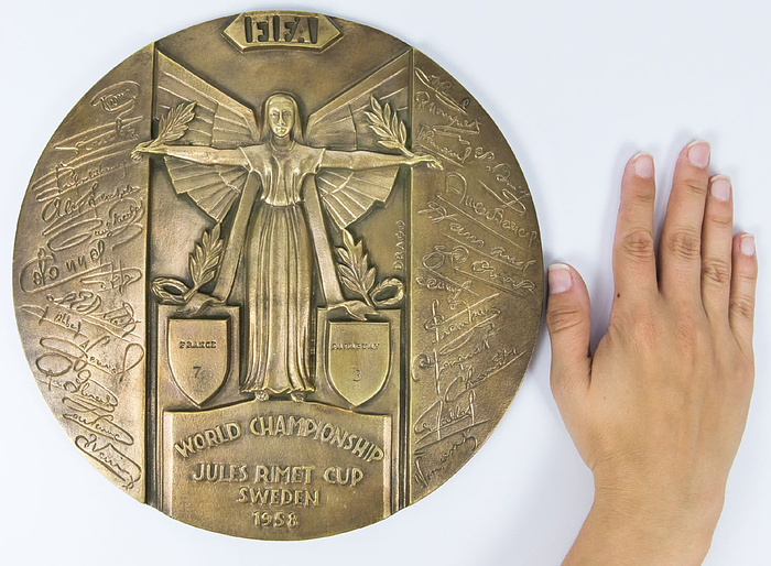 Bronzeplakette WM 1958  | Große Erinnerungsplakette aus Frankreich für die Spiele der französischen Nationalmannschaft bei der Fußball - Weltmeisterschaft 1958 in Schweden mit der Inschrift "FIFA World Championsship Jules Rimet Cup Sweden 1958. France 7 - Paraguay 3" mit den Unterschriften (in der Platte) aller französichen Nationalspieler die am World Cup 1958 teilnahmen. Bronze (Gewicht: 2,6 kg), 25,5 cm.