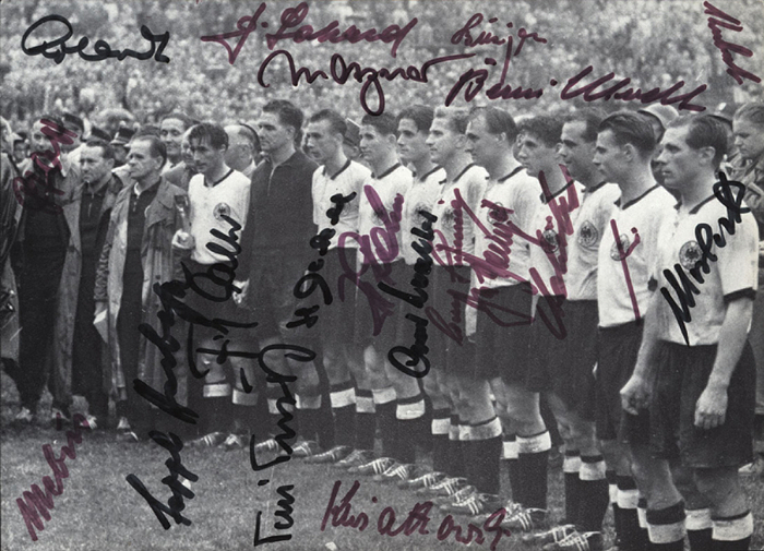  - Black-and-white press photograph of the 1954 World Cup-winning German national football team at the awards ceremony following the 1954 World Cup final between Germany and Hungary (3–2) on July 5, 1954, in Bern. Featuring 20 original signatures of the German players and the coach Spee Herberger. (F. Walter, Turek, Eckel, Rahn, O. Walter, Liebrich, Posipal, Schäfer, Mai, Morlock, Herberger, Erhardt, Laband, Metzner, Biesinger, Klodt, Kubsch, Kwiatkoski, Mebus, Pfaff). 18 x 13.5 cm. --The signatures of Hermann, Kohlmeyer, and Bauer are missing. —This piece comes directly from the collection of Werner Liebrich (1927–1995). 1954 World Cup Winner. 16 DFB senior international caps. 1. FC Kaiserslautern: 365 matches; 2-time German Football Champion (1951 & 1953). Condition: A-