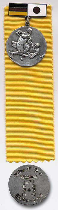 Teilnehmermedaille 1971  | Länderspielmedaille für das Eishockeyspiel Deutschland gegen Japan 1971 mit farbig emaillierten Steg und gelben Seidenband. Bronze, versilbert. 12x4,2 cm