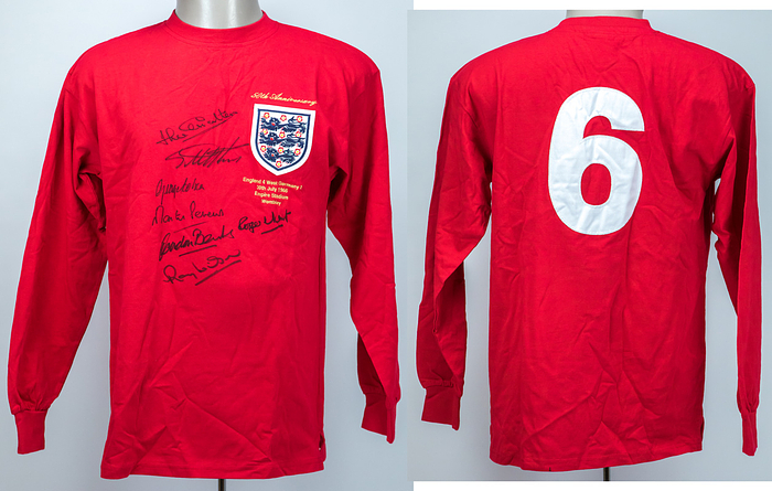  - World Cup 1966 England: Official replica jersey of the English Football Association, commemorating the 50th anniversary of the 1966 World Cup Final, featuring an embroidered match print: "England 4 – West Germany 2. 30th July 1966. Empire Stadium Wembley." Bearing the squad number "6" of Bobby Moore. Signed by 7 members of England's 1966 World Cup-winning squad: Jack Charlton (1935–2020), Geoff Hurst, George Cohen (1939–2022), Martin Peters (1943–2019), Gordon Banks (1937–2019), Roger Hunt (1938–2021), and Ray Wilson (1934–2018). --Long-sleeved, cotton, featuring an embroidered FA logo patch and a sewn-on linen back number. Size M. All signatures are clean and clear! Condition: A
