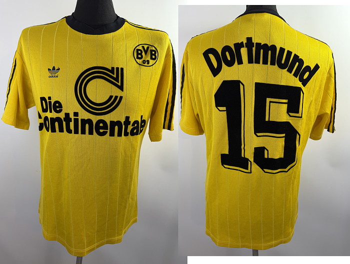  - Original match-worn Borussia Dortmund player shirt, No. 15, worn during the 1989/1990 season by a substitute player. The shirt originates from the collection of Matthias Herget. Status: ABA. Short-sleeve shirt; Size 7/8 (L); Flocked BVB crest; Rubberized manufacturer logo; Back number applied via wet-flock process; 50% Cotton, 50% Polyamide; Made in Yugoslavia. Condition: A