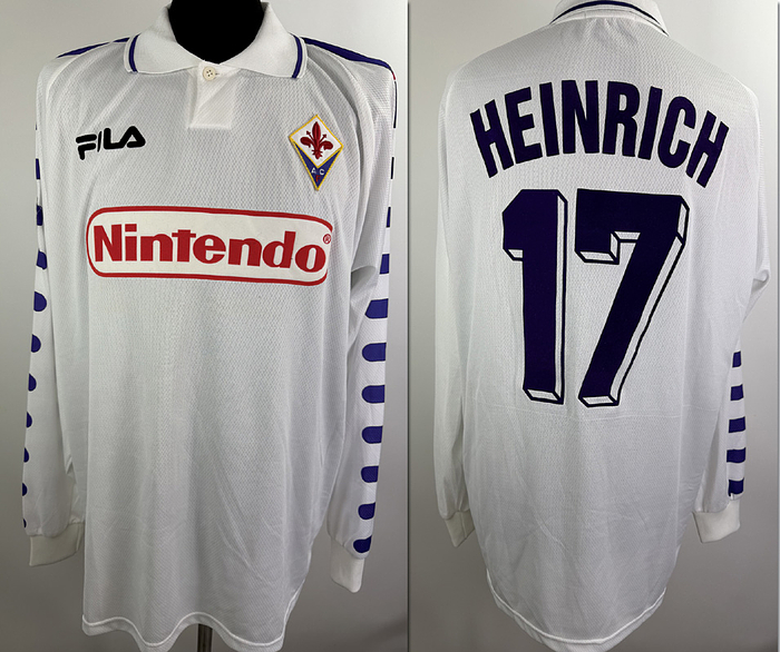 Jörg Heinrich - Shirt AC Florenz 1998 - Original match-worn AC Fiorentina player shirt, number 18 (Jörg Heinrich). Worn in the match against Lecce (Coppa Italia) on October 28, 1998. Swapped shirt. The shirt comes from the collection of swiss International David Sesa. Status:AAB. Long-sleeved shirt; size XL; club crest stitched on; Fila manufacturer logo and sponsor (Nintendo) applied via flocking; player number and name applied via flocking; 100% polyester; Made in Italy. Condition: A