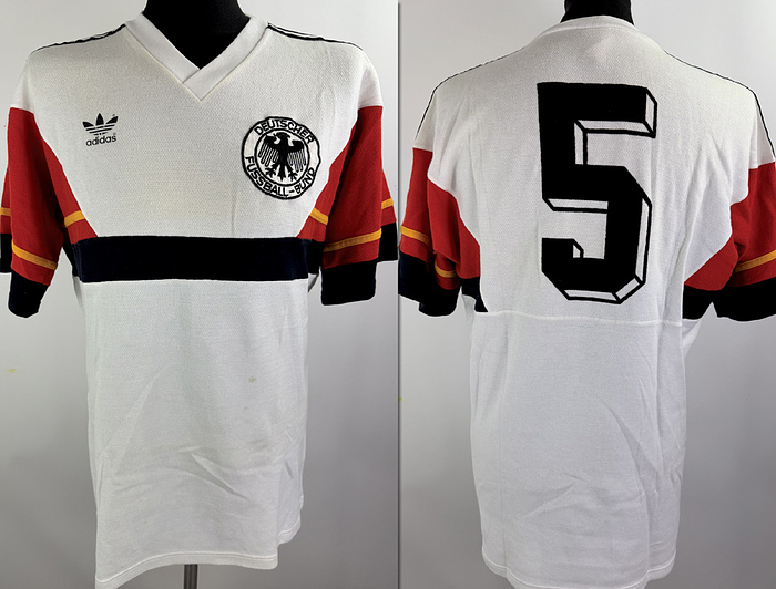 DFB - Trikot 1986 WM  | Für das WM-Finale 1986 in Mexiko gegen Argentinien wurde dieses besondere Trikot ursprünglich für Matthias Herget vorbereitet. Das Shirt basiert auf dem seltenen weißen adidas-Design im Stil des damaligen Trainingsoberteils.ach damaliger Entscheidung der FIFA kam dieses Trikot im Finale jedoch nicht zum Einsatz. Da Argentinien als Heimteam geführt wurde, galt die Farbkombination des weißen deutschen Trikots im Zusammenspiel mit den hellblauen argentinischen Streifen als zu ähnlich. Um mögliche Verwechslungen zu vermeiden, lief das DFB -Team deshalb erneut im grünen Auswärtstrikot aus dem Vorrundenspiel gegen Uruguay auf. Status AAA,