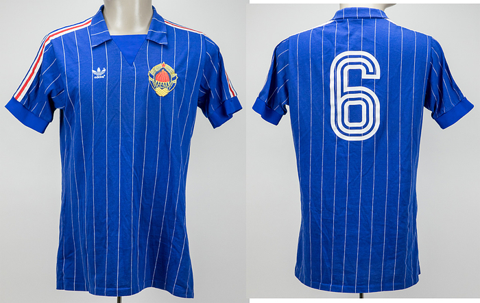  - Original match-worn Yugoslavia playershirt, number 6, belonging to Blaž Sliškovic, from the match against Germany on May 11, 1986, in Bochum. This jersey was obtained via a shirt swap with German international and 1990 World Cup champion Rudi Völler. The jersey comes from the personal circle of Rudi Völler’s family. Status: AAA. --Short-sleeved jersey; size 7/8, L; association logo sewn on; manufacturer's logo applied as a rubberized print; number on the back applied as a rubberized print; 50% cotton, 50% polyester; made in West Germany. Condition: A-