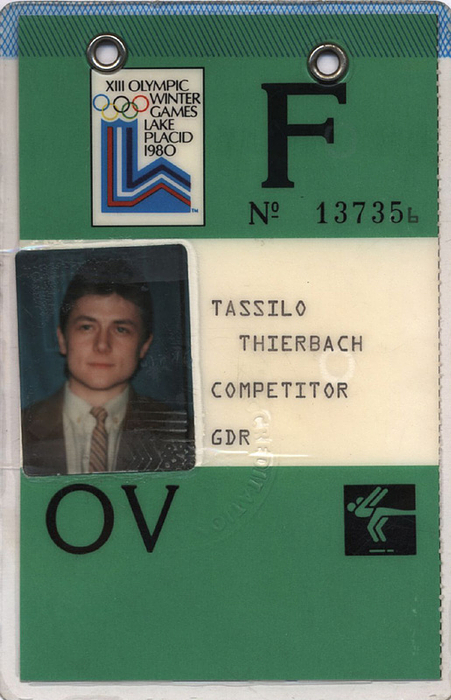 Olympia-Ausweis 1980  | Offizieller Ausweis von den Olympischen Spielen 1980 in Lake Placid von Tassilo Thierbach (1956-2025; DDR) 6.Platz im Eiskunstlaufen der Paare. Mit Passfoto und original Signatur auf der Rückseite. Kunststoff, 13x8,5 cm.
