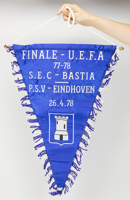 Bastia,SEC - Spielwimpel 1978  | Offizieller Spielwimpel des SEC Bastia für das UEFA - Pokalfinale 1978 mit der gestickten Aufschrift "Finale - UEFA 77 - 78. SEC Bastia - PSV Eindhoven 26.4.1978" (0:0) mit aufgesticktem Vereinslogo des Traditionsclubs aus Korsika. Seide mit Seidenfransen. Messingstange mit Messingkugeln. 59x42 cm