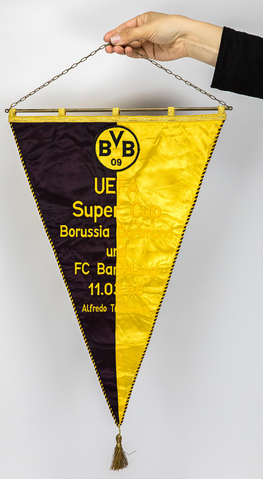 Dortmund,Borussia-Wimpel  | Offizieller Spielwimpel von Borussia Dortmund "UEFA CUP Super - Cup  Borussia Dortmund und FC Barcelona 11.03.1998 Alfredo Trentalange" (1:1). Zweifarbiger Seidenwimpel mit seidenbesticktem Schriftzug und aufgesetztem besticktem Vereinslogo aus Leinen. Schwarz-gelbe Seidenbordüre, Goldbrokatleiste und Goldbrokatbommel. Messingstange mit  Messingkette. 47x32 cm (ohne Bommel).