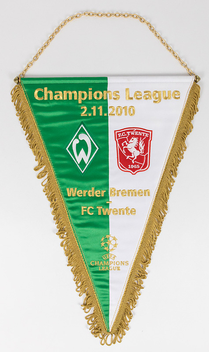  - Match pennant CL 2010.  „Champions League 2.11.2010. Werder Bremen - FC Twente“ Green and white embroidered silk pennant with both club emblems, golden braid and fringes, with metal chain and rod, size 28x41cm. One large pennant of thie type was produced for the match and 11 in this size were presented to the referees and UEFA Officials! Condition: A
