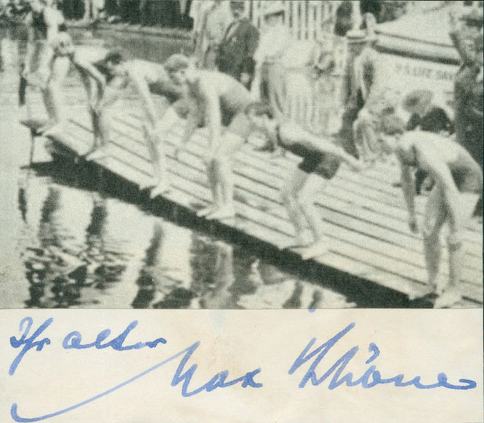 Schöne, Max  | (1880-1961) Blancobeleg (8,5x2,2 cm) mit original Signatur von Max Schöne (GER) in Tinte. Goldmedaille im Schwimmen über 200 m bei den Olympischen Spielen 1900. Aufmontiert mit einem S/W-Magazinbild auf einem Karton, 8,5x7,5 cm