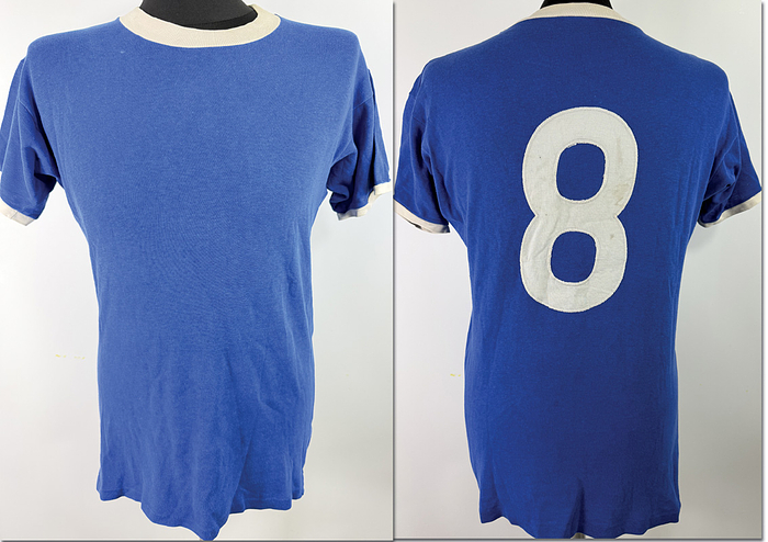  - Original match-worn Schalke 04 player's jersey (number 8) from the 1970s, belonging to Reinhard "Stan" Libuda. Manufacturer: Erima. Status:ACA.  It comes from the collection of the former DFB team bus driver. Short-sleeved shirt; size M; linen back number stitched on; minor signs of storage; shows signs of match use; 100% cotton; made in West Germany. --Match-worn shirt swapped by an English Premier League player with Libuda after the game. The jersey comes directly from the family of the late English player. Condition: A