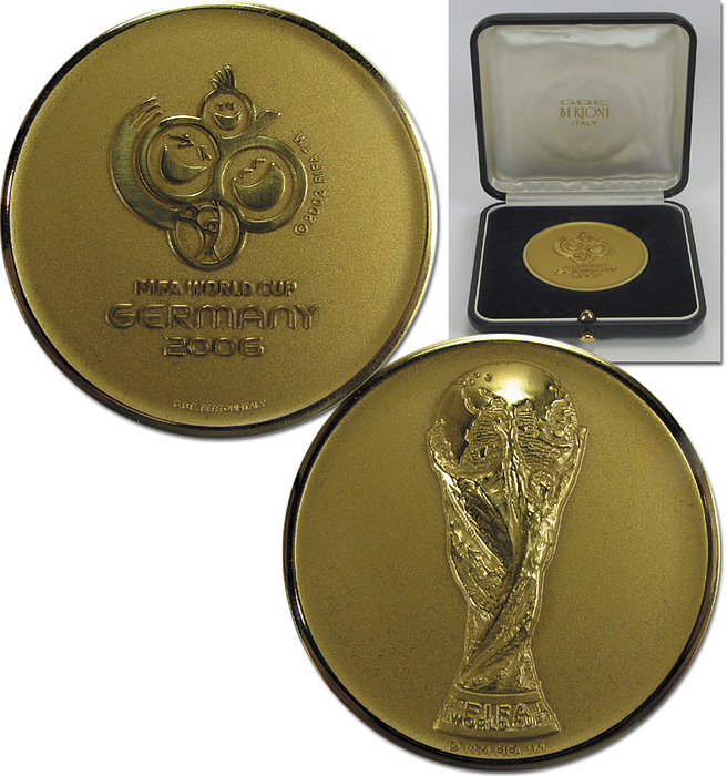  - World Cup 2006. Official participation medal „FIFA World Cup Germany 2006“ Cast in Bronze, gold plated made by Bertoni. Presented to all players, trainers and officials of the countries qualifying for the 2006 Finals in Germany. Very rare medal in original case. Diameter 5.1 cm. Personal medal belonging to FIFA referee Volker Roth. The medal comes directly from his estate. Condition: A