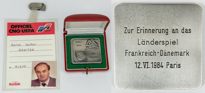 Ausweis + Ehrenplakette EM 1984  | Eröffnungsspiel der UEFA Euro 1984 Frankreich v Dänemark am 12.6.1984 in Paris. Schiedsrichter dieses Spiels: Volker Roth (GER; 1952-2025). Original Ausweis der UEFA Euro 1984 von Volker Roth, 12,5x8 cm. Und Offizielle Ehrenplakette des Deutschen Fußballbund mit dem Logo des DFB und Inschrift "Volker Roth Spfr.Salzgitter". Rückseitige Inschrift "Zur Erinnerung an das Länderspiel Frankreich - Dänemark 12. VI. 1984 Paris". Tombak, 4,8x4,8 cm in original Box. Unikat!