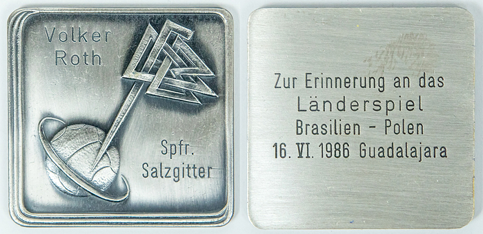  - 1986 FIFA World Cup Round of 16 match between Brazil and Poland (4–1) on June 16, 1986. Match referee: Volker Roth (GER; 1952–2025). Official commemorative plaque from the German Football Association (DFB) featuring the DFB logo and the inscription "Volker Roth Spfr. Salzgitter." Inscription on the reverse: "In memory of the international match Brazil vs. Poland, 16 June 1986, Guadalajara." Tombac, 4.8 x 4.8 cm. Unique item! --The DFB awarded these commemorative plaques to German referees for international assignments. The medals come directly from the estate of Volker Roth. Condition: A