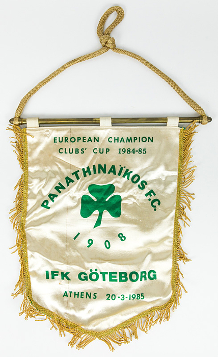  - Match pennant from Panathinaikos Athens: "European Champion Clubs Cup 1984-85 Panathinaikos FC - IFK Göteborg. Athens 20.3.1985". Green-printed silk pennant featuring gold-braid fringe and a heavy brass crossbar with a gold-braid cord. 40 x 33 cm. Personal copy belonging to German referee Volker Roth (1942–2025), who was part of the officiating team for this UEFA match. --v Condition: A-