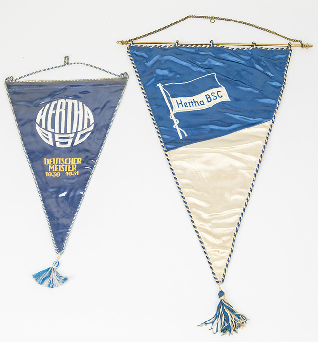 Hertha BSC - Spielwimpel  | Original Spielwimpel "Hertha BSC" Blau-weißer Seidenwimpel mit aufgestickter Vereinsfahne. Mit Blau-weißer Seidenbrodüre und Seidenbommel, Messingstange. 43x30 cm. (ohne Bommel) und Souvenirwimpel mit bestickter Aufschrift "Hertha BSC Deutscher Meister 1930 1931" mit Seidenbommel, 32x22 cm (ohne Bommel. Beide ca. 1980