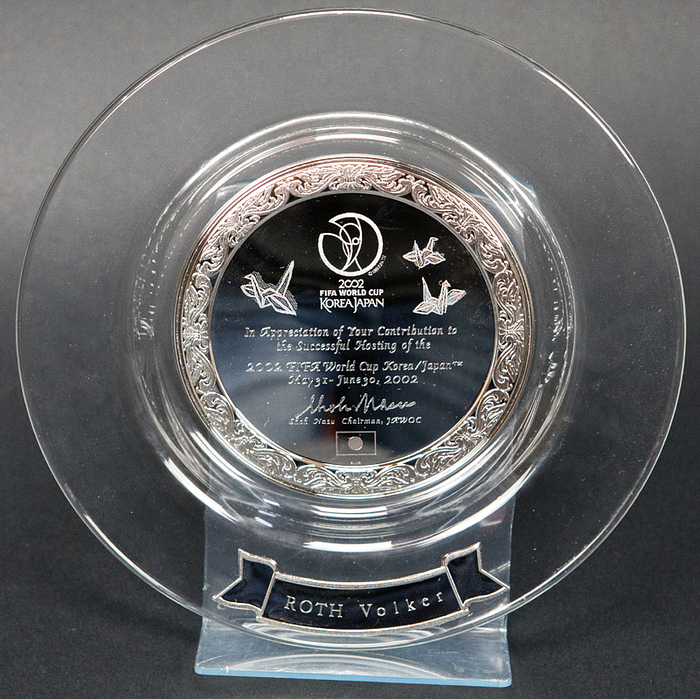 Ehrenteller WM 2002  | Offizieller Ehrenteller des OK der Fußball - Weltmeisterschaft 2002 für Volker Roth. Glas mit Silberplaketten (gepunzt "Silver", 500er). 21 cm. In original Box.