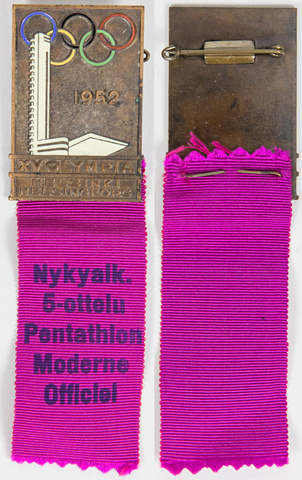 Teilnehmerabzeichen 1952  | Teilnehmerabzeichen „Pentathalon Moderne Officiel“ für die Olympischen Spiele Helsinki 1952. Bronze, teiweise farbig emailliert. Mit original pinkfarbenen Seidenband, 11x3,2 cm.