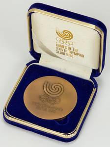  - Participation medal for athletes who participated in the Olympic Games in Seoul 1988. Bronze, embossed in gold with „Games of the XXIVth Olympiad Seoul 1988“, and the Olympic Rings. In original presentation case lined with silk and satin. Medal size 6 cm. Condition: A - Bild 3