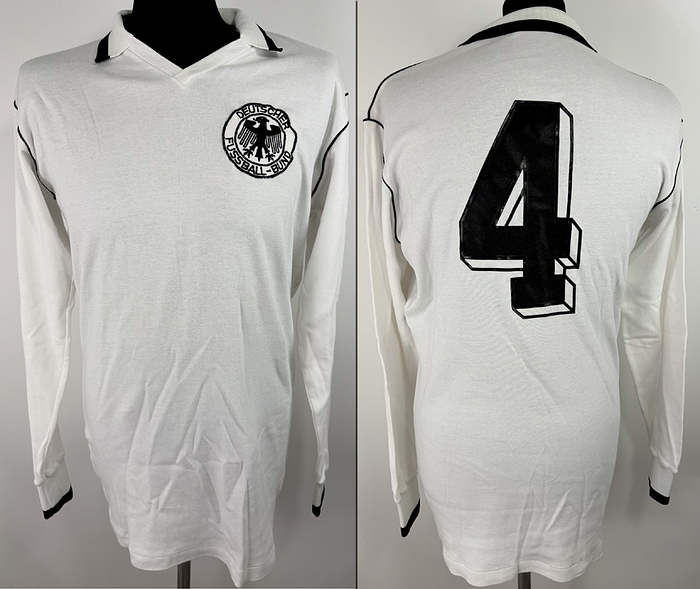  - Original match-worn DFB player's shirt (No. 4) belonging to Rolf Rüssmann from the 1978 World Cup. Worn during the match against the Netherlands on June 18, 1978, in Córdoba. The shirt comes from the collection of a former DFB staff member. Status AAB. Long-sleeved shirt; size L; sewn-on DFB crest; the rubberized Erima manufacturer's logo has detached; applied player number; 100% cotton. Condition: A