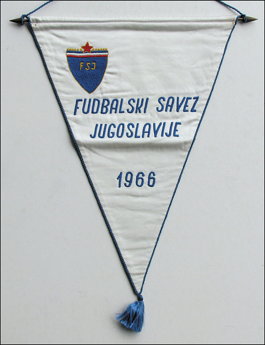  - Football Match Pennant 1966. Jugoslavia: Blue embroidered match pennant of the Yugoslavia national team from 1966, "Fudbalski Savez Jugoslavije 1966," with the embroidered "FSJ" logo. Silk pennant with blue silk cord and pompom. 43 x 33 cm (without pompom).  Was awarded on occassion of an international match. From the collection of a FIFA referee. Condition: A-