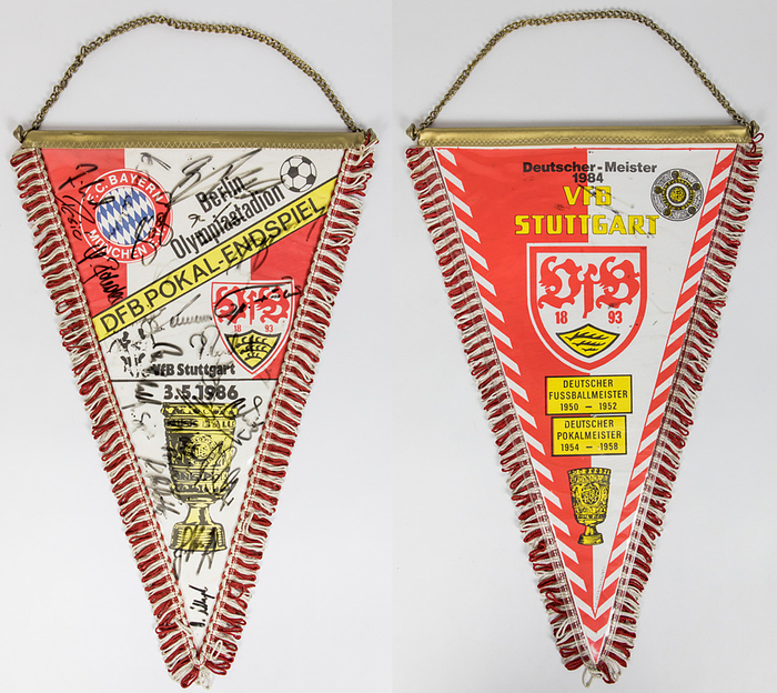 Stuttgart,VfB - Wimpel 1986  | Souvenirwimpel des VfB Stuttgart vom "DFB- Pokal - Endspiel 3.5.1986, Berlin Olympiastadion. 3.5.1986" mit ca. 20 original Signaturen der Spieler von VfB Stuttgart und FC Bayern München. Farbig bedruckter Wimpel mit rot-weißen Seidenfransen und Metallstange. In Klarsichtschutzhülle eingenäht, 41x27cm.