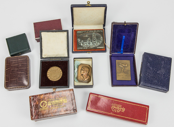 Siegermedaille 1928 + Diploma  | Nachlass von Lotti Mühe (GER; 1910-1981). Bronzemedaillengewinnerin über 200 m Brust bei den Olympischen Spielen Amsterdam 1928. Sie hatte vor der Olympiade 1928 zweimal den Weltrekord 100 m und 200 m verbessert. Sie gewann bei den Schwimm - Europameisterschaften 1927 die Silbermedaille über 200 m Brust. 3fache deutsche Meisterin. Dabei:  1) Siegermedaille „IXe Olympiade Amsterdam 1928“. In Bronze, 5,5 cm im Pappetui. 2) Offizielles Olympia-Siegerdiplom für den 3.Platz im  Brustschwimmen für Lotti Mühe „Diploma. IX.Olympiade 1928 Amsterdam. 3e Pijs L.Mühe Duitsland voor Swemmen (200 M Schoolsslag Dames“.  Gestaltung C.J. van der Hoef. Signiert vom Präsidenten des OK A. Schimmelpenninck und dem IOC-Präsidenten Baillet-Latour. (64x44 cm). Urkunde leicht fleckig 3) Silberpokal der Schwimm - Europameisterschaften 1927 in Bolgona für den 2.Platz mit der Sockelgravur "Campionati Europej di Nuoto…1927". Silber (gepunzt 800er Silber, Gewicht, 314 Gramm). Höhe: 21,5 cm. In original Box. 4) Original Wappen der deutschen Olympiamannschaft von 1928. Hat Lotti Mühe von einem Trainingsanzug oder Wettkampfbadeanzug entfernt. Leine mit Seide bestickt, 8x6 cm. 5) Original Abzeichen des DSV für die Teilnehmer am Schwimmländerkampf 1929 mit der Inschrift "Länderkampf Schweden - Deutschland 1929 in Halberstadt". Silber (gepunzt 950er), vergoldet, 3,8x3,5 cm. In original Box. 6) Personalausweis der BRD von Lotti Mühe-Escherich mit Passfoto und original Signatur mit "Lotti Escherich". 10,5x7,5 8 Seiten. 7) Persönliche Einladung als "Ehrengast" für die gesamten Olympischen Spiele Berlin 1936 für ehemalige Olympiasieger, 27x22 cm. Dabei ein Blatt von dem Empfang der ehemaligen Olympiasieger am. 4.7.1936 mit 21 original Signaturen von Olympiasieger von 1896-1936, dabei die Signatur von Spyridon Louis (GR; 1873-1940), den Goldmedaillengewinner im Marathom von 1896 je 30x21 cm. 8) Urkunde zum Meisterschaftsabzeichen von Lotti Mühe des DRfL aus dem Jahre 1937 mit dem Text "Lotti Mühe Holdesheimer Schwimmverein dem Deutschen Meister 1908 im 200 m Brustschwimmen d. Frauen m. 3:18,4 min", 43x30 cm. Bei dieser Urkunde unterlief dem Hersteller ein großer Fehler. Statt 1929 in dem Jahr in dem Mühe die DM 3:18,4 min gewann trug er das Jahr 1908 ein! Diese Urkunde wurden 1937 teilweise posthum an verdiente Athleten ausgeben. 9) 3 Siegerabzeichen von regioalen Schwimmwettbewerben. Alle aus Silber. 10) ca. 15 Siegerabzeichen von regionalen Schwimmwettbewerben, alle gewonnen von Lotti Mühe. 11) 5 Fotoalben von Lotti Mühe aus der Zeit von 1920 -1945  it privaten Fotos (ca. 200 Fotos). 12) divererse Dokumente und Brief an Lotti Mühe aus der Zeit von 1925-1945. 13) Kopie der Diplomarbeit von Lottu Mühe aus dem Jahre 1932 "Trainingsschulung der Frau für den Schwimmwettkampf. 46 Seiten. 14) Mauskript von Florentine Naylor (1922-2013) "Rückblick auf die Jahre 1940 - 44 anhand von authentoschen Briefen an eine Freundin". Bei diesen Briefen handelt es sich um Briefe an Lotti Mühe. Naylor ar eine Schriftstellerin und Übersetzerin.
