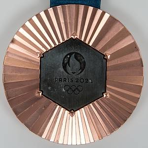 Siegermedaille 2024  | Bronzemedaille der Olympischen Spielen Paris 2024 für den 3.Platz im Taekwondo für einen amerikanischen (Süd - Mittel) Athleten mit der Aufschrift "Jeux de La XXXIIIe Olympiade Paris 2024". Kupferlegierung auf der Rückseite in der Mitte ein originalsechseckiges Stück Eisen aus dem Eiffelturm, das bei Renovierungsarbeiten entnommen wurde mit dem Symbol der Olympiade und der Inschrift "Paris 2024". Gewicht ca. 325 Gramm, 8,5 cm mit original Seidenband. In original Lederschatulle, ein dreifach klappbares (Triptychon-) Etui aus strukturiertem, violettem (blau/lila) Leder mit goldenen Olympischen Ringen und dem Paris-2024-Logo. Innen ausgeschlagen mit Verloursleder. Aufgesetzte Plakette für offiziellen IOC - Siegerpin für Bronzemedaillengewinner. 28x22x9 cm. Dabei zwei Echtheitszertifikate von Paris Mint!. - Bild 2