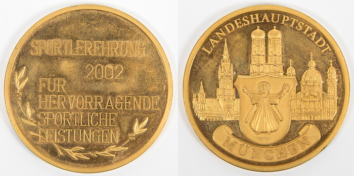 Kahn,Oliver - Ehrenmedaille 2002  | Offizielle Ehrenmedaille der Stadt München für Oliver Kahn mit der Inschrift "Sportehrung 2002 für hervorragende sportliche Leistungen". Tombak, vergoldet, 5 cm Die Medaille wurde für sportliche Erfolge im Jahr 2001 verliehen, in dem Jahr wo Bayern München mit Oliver Kahn den Weltpokal, die Champions League und Deutsche Meisterschaft gewann!.