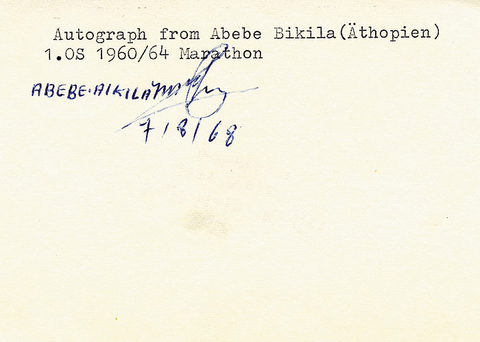 (1932-1973) Blancobeleg mit Originalsignatur von  Abebe Bikila. Äthiopischer Marathonläufer. Olympiasieger 1960+1964 im Marathonlauf. 10,5x8 cm.