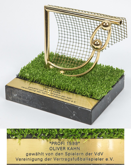 Oliver Kahn sculpture Profi of the year 1998 - Honorary Award Professional 1998 from the Association of Contractual Football Players (VdV) for Oliver Kahn. Sculpture made of gold-plated stainless steel (football goalkeeper in a parade in front of a football goal), with artificial turf on a marble base, 18x14x17 cm Weight: 2.2 kg. With mounted engraved brass plaque "Professional 1998 Oliver Kahn elected by the players of the VdV Association of Contract Football Players. This prize was awarded for the first time in 1998! --Members of the VdV are professional footballers in the Bundesliga who voted for the “Professional of the Year” from 1998 to 2003; from 2005 to 2008 this award was called Player of the Year. As of 2008, such honors are only available as "11 of the Year". Oliver Kahn was again voted “Professional of the Year” in 2001.  Around 2010, a well-known collector from Munich acquired this medal from Oliver Kahn's family circle. Condition: A-