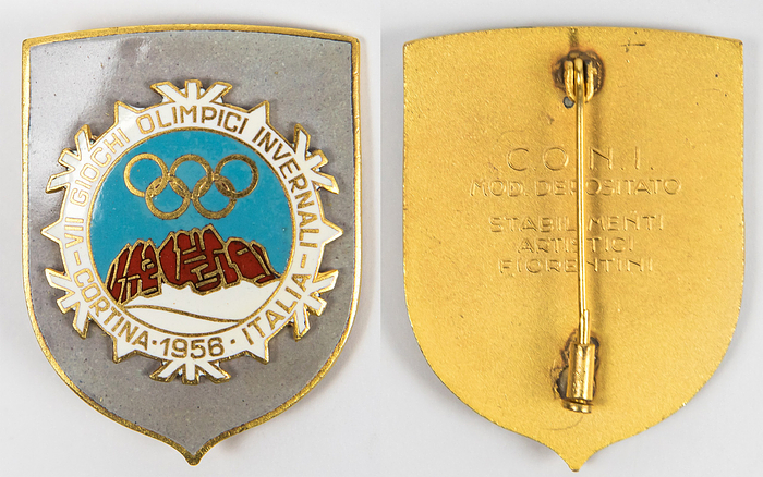Offizielles Teilnehmerabzeichen der Olympischen Winter Spiele Cortina d`Ampezzo 1956 für Gäste des OK, vergoldete Bronze, mehrfarbig emailliert, 4,5x3,5 cm. Dabei original Verpackung aus Papier mit der Jahreszahl "1956".