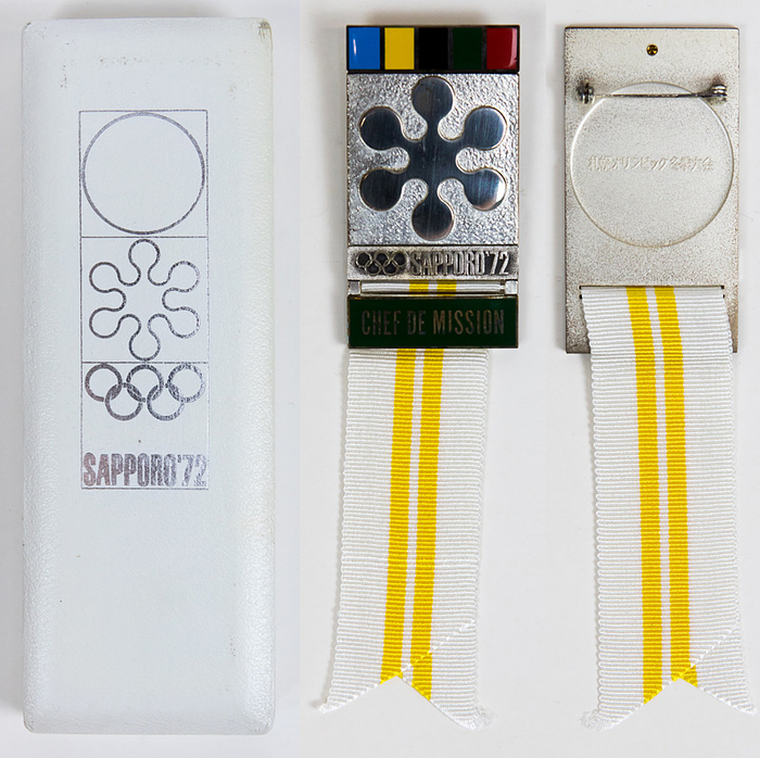 Participation Badge: Olympic Games Sapporo 1972. - Official participation badge "Chef de Mission". Personal badge of Walter Tröger (GER) for the Olympic Games Sapporo 1972. Silver plated bronze. Green enamelled inscription. With white silk ribbon with two yellow stripes, 15x3.8cm. In original box with original. Badge : Condition A-; Box: Condition. B+ Condition: 