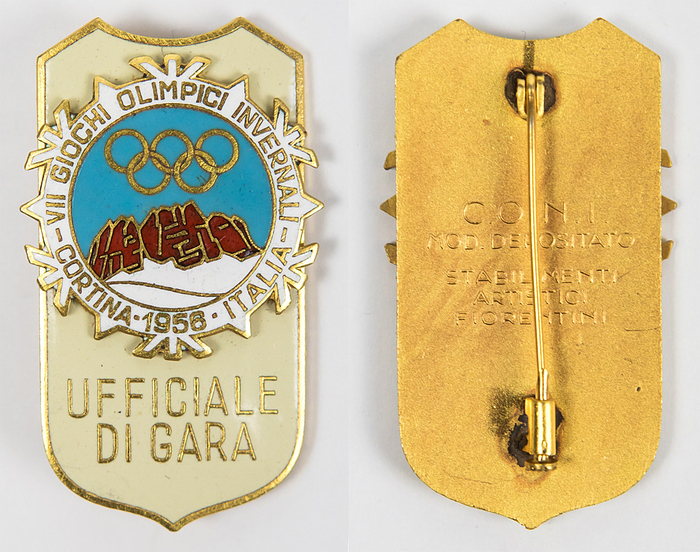 Olympische Winterspiele Cortina d´Ampezzo 1956. Offizielles Teilnehmerabzeichen mit der Aufschrift "Ufficiale di Gara" (Offizieller der Jury). Bronze, vergoldet, farbig emailliert, 5,3x3,2. Mit original Papiertüte!!.