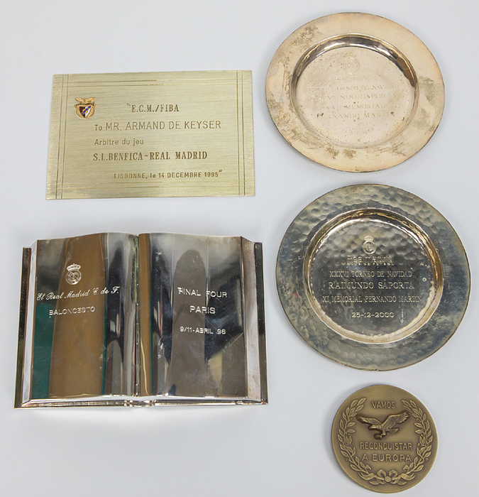 Basketball Real Madrid hochwertige Erinnerungsstücke an die Final Four Turniere und die Weihnachtsturniere alle mit dem eingravierten Logo von : 1) Versilbertes Zigarettendose in Form eines Buches mit dem Schriftzug "Final Four Paris 9/11 Abril 96". Neusilber, 17x11x3 cm. 2) "XXXVII Torneo de Navidad Raimundo-Saporta 25-XII-2001" mit Namensgravur eines Schiedsrichters. Neusilber, 13 cm. 3) "XXXVI Torneo de Navidad Raimundo-Saporta 25-12-2000" mit Namensgravur eines Schiedsrichters. Neusilber, 13 cm. 4) Erinnerungsplakette "ECM/FIBA to Mr. Armand de Keyser. Arbitre du jeu Benfica - Real Madrid. Lisbonne, le 14 decembre 1995", Neusilber mit aufgesetztem emailliertem Vereinsemblem von Benfica, 15x10 cm. 5) Basketball Erinnerungsmedaille "Campeao Nacional 1993.1994" von Benfica Lissabon, di anläßlich des Spieles gegen Real Madrid vergeben wurde, Bronze, 6,8 cm.