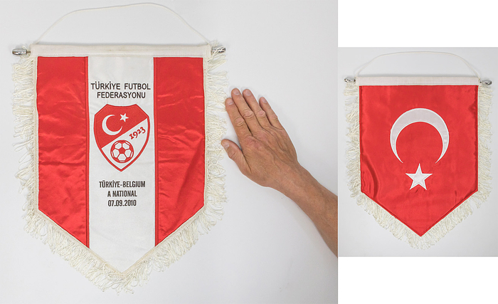 Türkei - Spielwimpel 2010  | Offizieller Spielwimpel für das UEFA Euro Qualifikationsspiel Türkei v Belgien (3:2) am 07.0.2010 in Istanbul mit der gestickten Aufschrift "Türkiye - Belgium A National 07.09.2010". Mit aufgesticktem Verbandslogo des Fußballverbandes der Türkei. Rückseite  mit bestickter Landesflagge der Türkei. Seidenwimpel mit weißen Seidenfransen, Metallstange mit verchromten Kugeln. 44x34 cm.