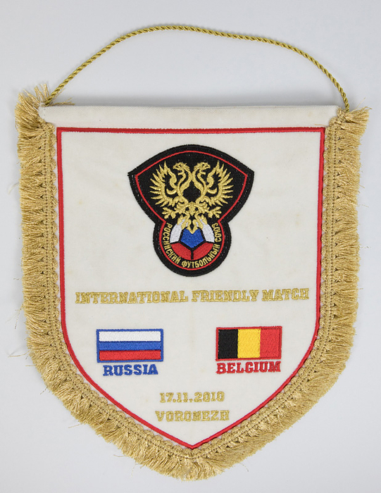 Football Match pennant 2010 Russia v belgium - Original match pennant of the Russian Football Federation for the 2010 friendly match against Belgium, featuring gold brocade embroidery with the words "International Friendly Match Russia - Belgium 17.11.2010 Voroneze" and the embroidered FA Russia logo and the two national flags. Gold brocade fringes with a gold brocade loop, 30 x 25 cm. --This pennant was presented to the Belgian team, the referees, and the UEFA observers. From the collection of an official of the Belgian Football Association. Condition: A