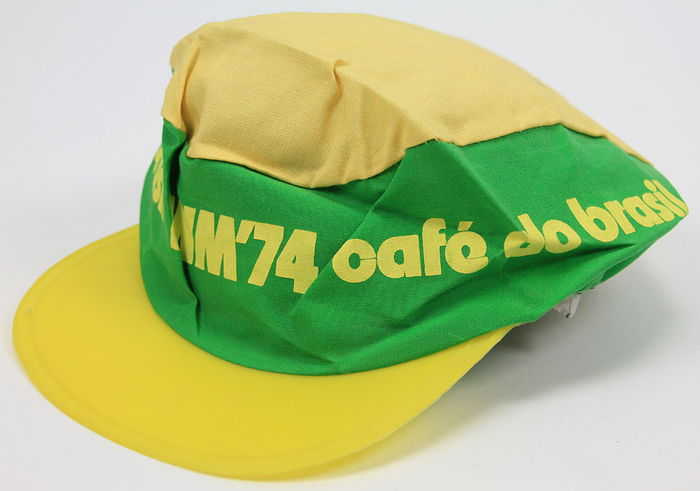 World Cup 1974. Brasil Souvenir hut - Fan cap for fans of the Brazilian national team for the 1974 FIFA World Cup, with a plastic visor and printed lettering "Cafe de Brasil WM '74." Linen, 25 x 19 cm. --Fan cap for fans of the Brazilian national team for the 1974 FIFA World Cup, with a plastic visor and printed lettering "Cafe de Brasil WM '74." Linen, 25 x 19 cm. Condition: A