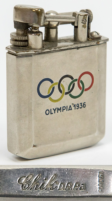 Feuerzeug 1936  | Verchromtes Feuerzeug mit farbigen emaillierten Olympischen Ringen und der Inschrift "Olympiade 1936". Marke: "Chik" und der Punze "Foreign".  4,5x3,7x1,2 cm.