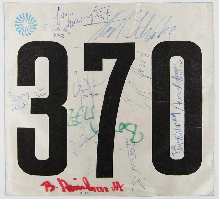 Original Startnummer "370" von den Olympischen Spielen München 1972 für die Leichtatheltik - Wettbewerbe.  25x23 cm. Mit 12 original Signaturen von Olympiateilnehmern der Olympiade 1972.