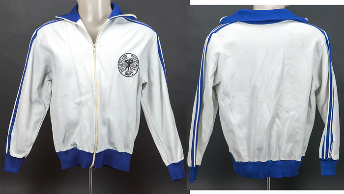 Germany match worn suit 1971 Germany v Poland - Original match-worn Germany tracksuit jacket worn by Werner Weist in the DFB U23 international match between Germany and Poland on November 16, 1971 in Bremen. Status: AAA. On November 17, 1971, the German senior national team played against Poland and wore the same tracksuit jackets! --White and blue jacket, brand adidas (55% synthetic; 45% cotton); size 6; sewn-on DFB logo; ----Jacket comes directly from the Werner Weist collection (1949-2019) - Borussia Dortmund 1968 - 1971 (72/34), Werder Bremen 1971-1977 (145/33), Stuttgarter Kickers (1977-1978; 10/1); 3x DFB U-23 1970 + 1971). The buyer receives a certificate of authenticity and confirmation from the Weist family regarding the origin of the pieces. Condition: A-