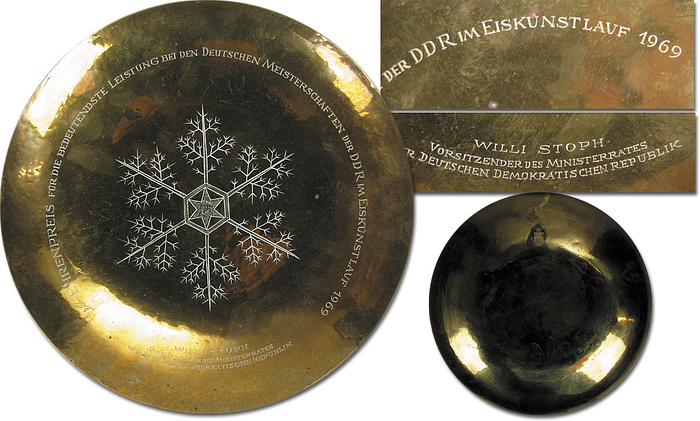 "Ehrenpreis für die bedeutendste Leistung bei den Deutschen Meisterschaften der DDR im Eiskunstlaufen 1969. Willi Stoph Vorsitzender des Ministerrates der Deutschen Demokratischen Republik". In der Mitter ein großes handgearbeitetes Eiskristall. Rückseite mit Punze "Handarbeit" und Künstlergarvur. 24 cm.