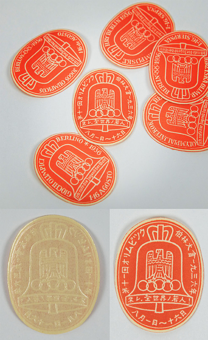 8 verschiedene Werbevignetten der Olympischen Spiele Berlin 1936 in verschiegenen Sprachen, je 3,5x2,8 cm.