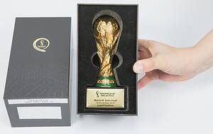 FIFA Weltpokal. Vergoldeter Tombakpokal auf schwarzem Sockel, dieser mit Metallschild mit WM 2022 Logo und Inschrift „FIFA World Cup Quatar 2022. Match 61 Semi-Final 13 December 2022 Lusial Stadium“ (Argentinien v Kroatien 3:0). Höhe 15 cm. In original Verpackung. - Bild 2