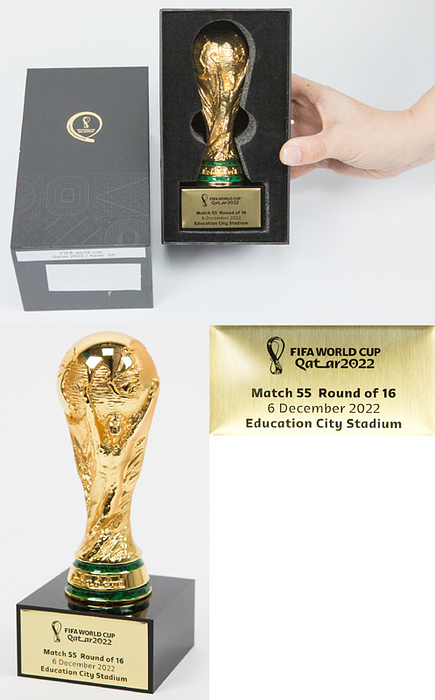 FIFA Weltpokal. Vergoldeter Tombakpokal auf schwarzem Sockel, dieser mit Metallschild mit WM 2022 Logo und Inschrift „FIFA World Cup Quatar 2022. Match 55 Round of 16 6 December 2022 Education City Stadium“ (Marokko v Spanien 0:0). Höhe 15 cm. In original Verpackung.