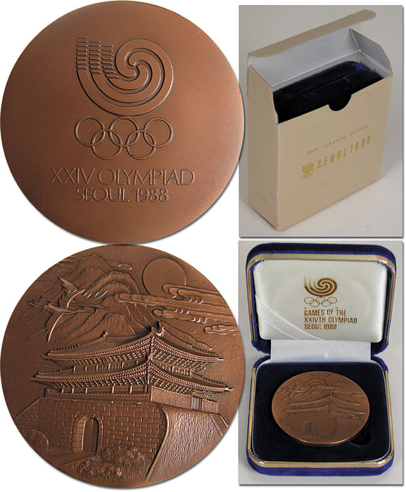Teilnehmermedaille für Sportler an den Olympischen Sommerspielen Seoul 1988. 6cm, Bronze. Im original Etui ausgelegt mit Samt und Seide und goldener Prägung mit Olympischen Ringen und Inschrift „Games of the XXIVth Olympiad Seoul 1988“.