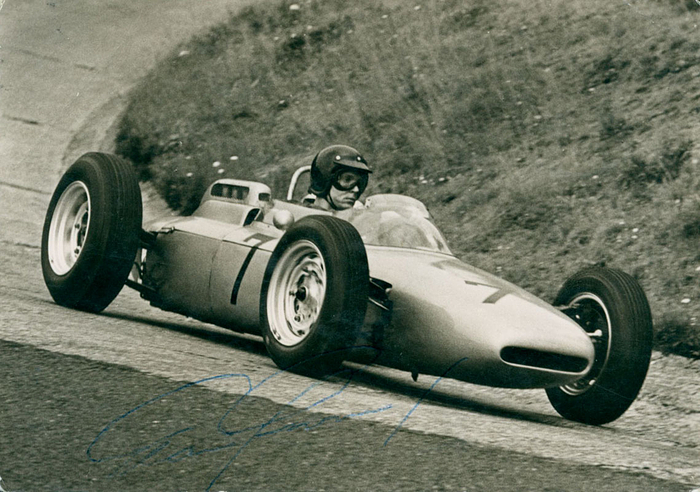 (1931-2018) S/W-Foto mit original Signatur von Dan Gurney im Porsche 1961/62. US-amerikanischer Automobil- und Formel-1-Rennfahrer und Konstrukteur. WM Vierter 1961 + 1965, 14,8x10,5 cm.