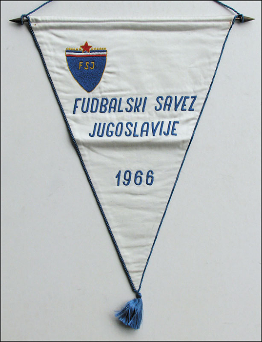 Blau bestickter Spielwimpel der Nationalmannschaft von Jugoslawien aus dem Jahre 1966 "Fudbalski Savez Jugoslavije 1966" mit aufgesticktem Verbands "FSJ". Seidenwimpel mit blauer Seidenkordel und Bommel.  43x33 cm. (ohne Bommel).