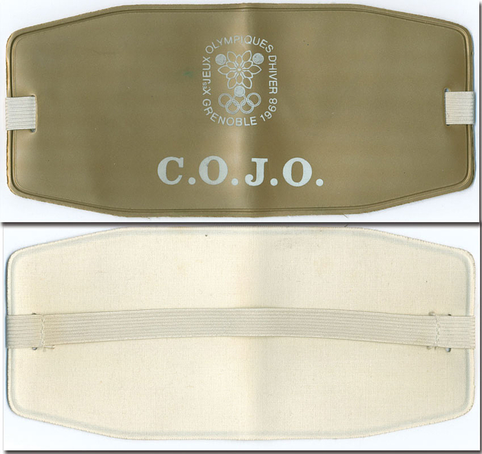 Original Armbinde der Olympischen Winterspiele 1968 in Grenoble mit der Aufschrift "C.O.J.O" in goldener Farbe (Für die Leiter des Organisationskomittees). Kunststoff mit Gummizug, 20,5 x9 cm.